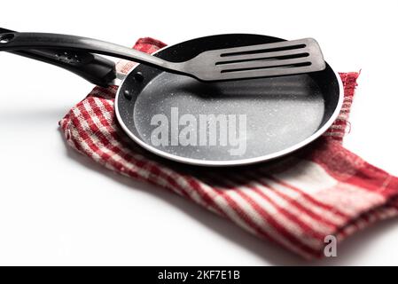 padella e spatola da cucina su fondo bianco Foto Stock