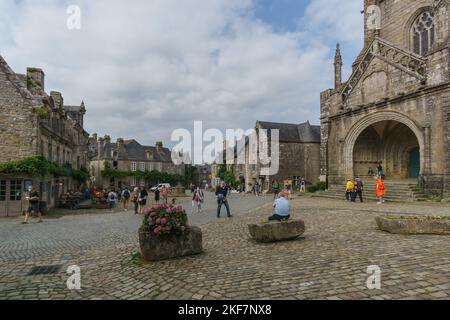 Tipica bella chiesa gotica bretone Flamboyant chiamata Eglise Saint-Ronan con piazza della città nel piccolo borgo medievale di Locronan, Bretagna, Francia Foto Stock