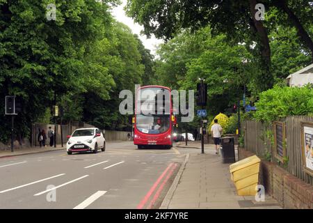 Autobus rosso di Londra che passa per Highgate Woods nella periferia di Londra Haringey, Londra, Regno Unito Maggio Foto Stock