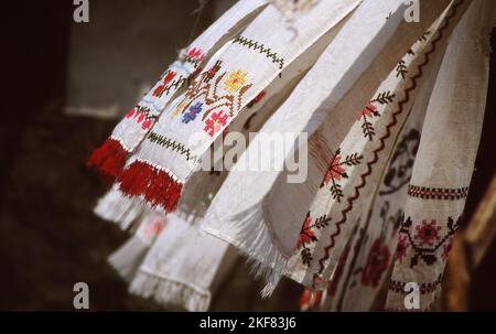 Romania, circa 1990. Stile di vita di una famiglia impoverita. Asciugamani cuciti a mano che asciugano fuori nel cortile. Foto Stock