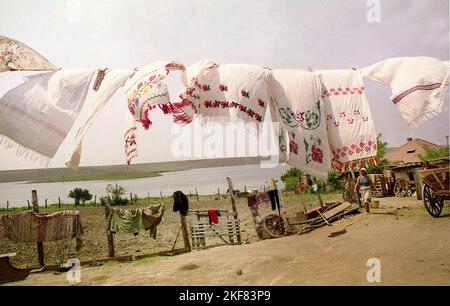 Romania, circa 1990. Stile di vita di una famiglia impoverita. Asciugamani cuciti a mano che asciugano fuori nel cortile. Foto Stock