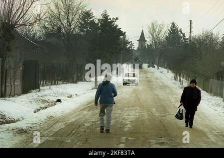 Giurgiu County, Romania, circa 1999. Persone sulla strada principale nel villaggio in inverno. Foto Stock