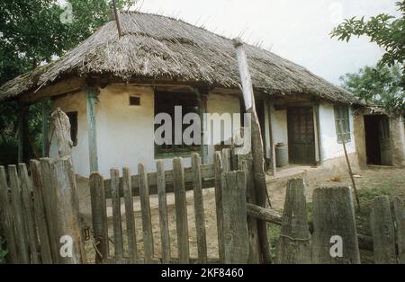 Semplice casa di fango tradizionale con tetto in paglia a Snagov, Romania, circa 2000. Foto Stock