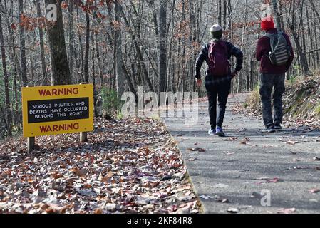 Due escursionisti passano davanti a un cartello segnaletico all'Hanging Rock state Park nel North Carolina. Foto Stock