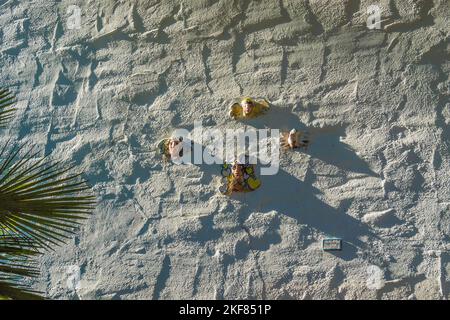 Volti di ceramici attaccati a una parete di stucco dell'artista di Santa Barbara Marge Dunlap. Foto Stock