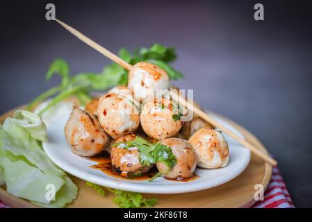 Polpette sul piatto con salsa piccante, polpetta alla griglia e palla di maiale, polpetta di carne sugli spiedini e cavolo fresco di verdure al coriandolo, cibo tailandese asiatico Foto Stock