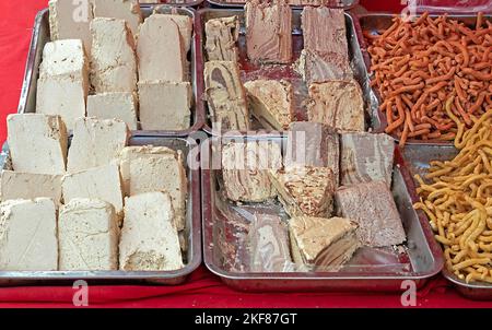 Tradizionale halva dolci arabi venduti sul mercato locale accanto a snack fritti Foto Stock