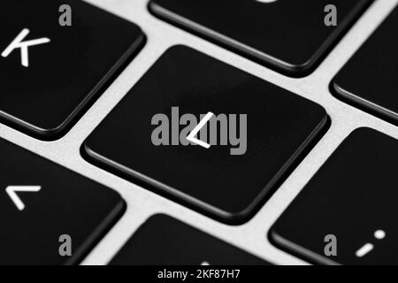 Primo piano di una tastiera grigia con tasti neri e caratteri bianchi Foto Stock