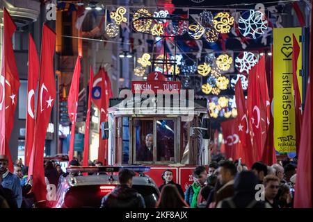 Istanbul, Turchia. 16th Nov 2022. Si vedevano persone che camminavano con il nostalgico tram tra le bandiere. Le bandiere turche sono messe lungo Istiklal Avenue dopo il mortale attacco terroristico a Beyoglu, Istanbul. Credit: SOPA Images Limited/Alamy Live News Foto Stock