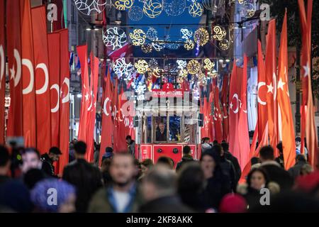 Istanbul, Turchia. 16th Nov 2022. Si vedevano persone che camminavano con il nostalgico tram tra le bandiere. Le bandiere turche sono messe lungo Istiklal Avenue dopo il mortale attacco terroristico a Beyoglu, Istanbul. Credit: SOPA Images Limited/Alamy Live News Foto Stock