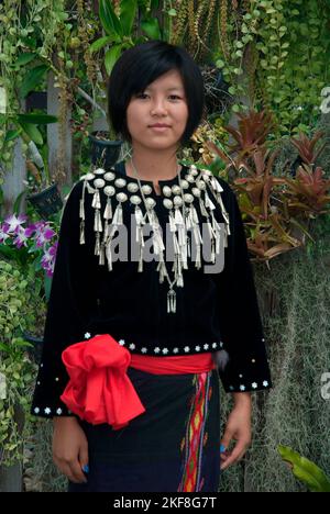 Una giovane donna non identificata Kachin o Jingpo in abito tradizionale indossa un headdress tradizionale che mostra , durante una performance culturale nazionale. Foto Stock