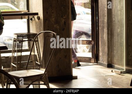 all'interno di una caffetteria con sedie alla luce del sole, una caffetteria Foto Stock