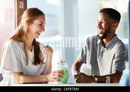 Ristorante, incontri e coppia bere smoothie e avere conversazione, parlare e chiacchierare. Amore, rapporto e uomo e donna seduti in un caffè urbano Foto Stock