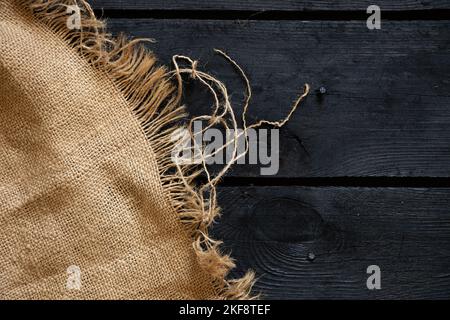 pannello di legno nero e tessuto marrone come sfondo, straccio sul pavimento, sfondo di legno Foto Stock
