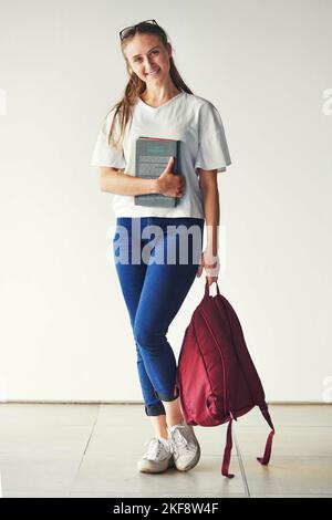 Studiare, libri e studenti in un college per l'istruzione, la conoscenza e la borsa di studio con un sorriso. Scuola, felice e ritratto di una ragazza pronta per Foto Stock