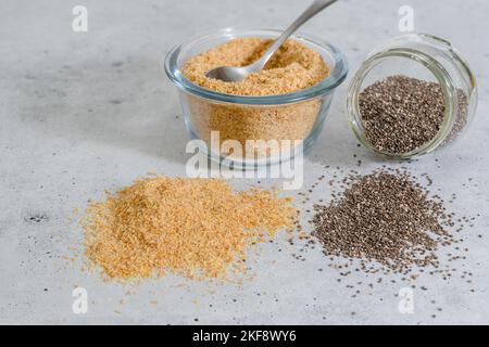 Pasto di semi di lino e semi di Chia chiudere in una ciotola di vetro sul tavolo da cucina Foto Stock