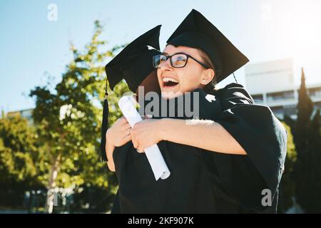 Abbraccio, laurea e gli studenti sorridono, successo per il successo e felice all'aperto in abito. Laurea femminile, abbraccio e laurea completa per l'istruzione Foto Stock