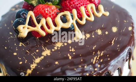 Il cioccolato fondente gocciola torta dolce di compleanno, frutta fresca lampone fragola mirtillo mirtillo mirtillo mirtillo mirtillo in cima, decorata con vernice commestibile oro Foto Stock