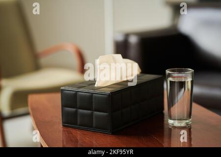 Primo piano di tessuti e vetro d'acqua sul tavolo preparandosi per i pazienti stressati in ufficio Foto Stock