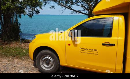 KOH CHANG, TRAT, THAILANDIA - 11 NOVEMBRE 2022: TRASPORTO DHL. DHL è leader mondiale nel settore della logistica. L'auto si trova sulla spiaggia. L'autista si riposa nell'esotica isola tropicale in una giornata di sole Foto Stock