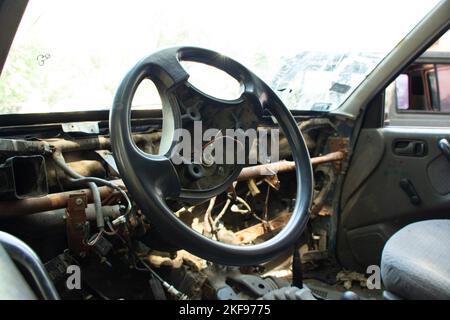 vecchia auto rotta si alza al sole, auto in un junkyard Foto Stock