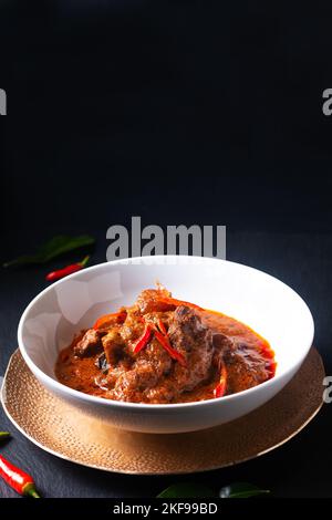 Cucina tailandese di manzo fatto in casa Red curry Panang su sfondo nero con spazio copia Foto Stock