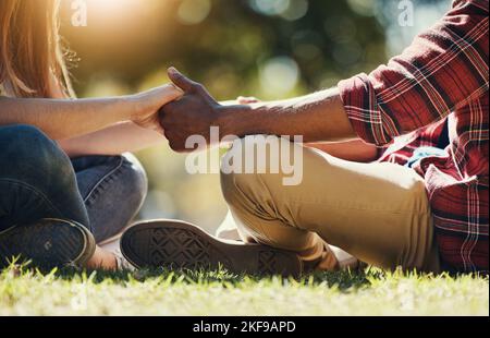 Vario, coppia e tenere le mani in un parco per amore, cura e affetto in un giardino estivo o parco. L'uomo e la donna interrazziali si legano mentre tengono la mano Foto Stock