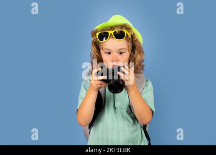 Fotografo di capretto con macchina fotografica in viaggio . Concetto di viaggio per bambini. Foto Stock