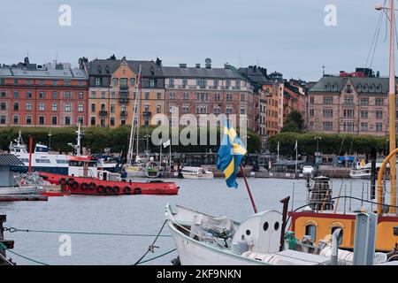 Stoccolma, Svezia - Settembre 2022: Vista sul mare colorato paesaggio urbano Strandhagen e navi con bandiera da Skeppsholmen Foto Stock