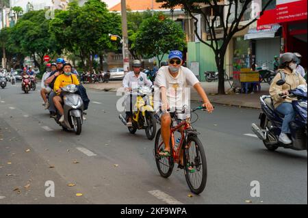 Saigon Street Life. Un'ora di punta sciame motociclistico condotto da un ciclista a ho Chi Minh City Foto Stock
