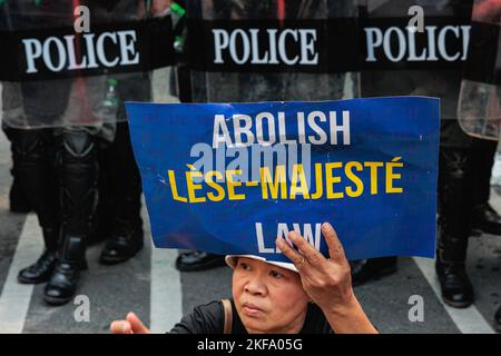 Bangkok, Thailandia. 17th Nov 2022. Un manifestante si trova di fronte alla polizia antisommossa mentre tiene un cartello che dice "abolire la legge lese-majeste” durante la manifestazione. I manifestanti pro-democrazia si sono riuniti all'incrocio di Asok vicino al Queen Sirikit National Convention Centre (QSNCC), dove l'APEC è tenuto per protestare a Bangkok. Credit: SOPA Images Limited/Alamy Live News Foto Stock