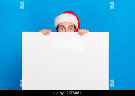 Foto dell'uomo funky che si nasconde dietro la bandiera tenere vuoto spazio presentando interessante proposta novità isolato su sfondo di colore blu Foto Stock