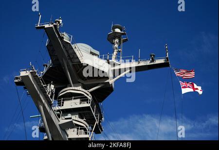 La bandiera degli Stati Uniti d'America e la Royal Navy si arruolano dalla USS Gerald R. Ford, la 'più grande nave da guerra del mondo', durante una visita mediatica mentre è ancorata nel Solent durante una sosta a Portsmouth sul suo primo dispiegamento. Data immagine: Giovedì 17 novembre 2022. Foto Stock