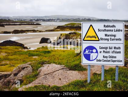 Gaelico e inglese avvertono di forti correnti e di tenere sotto controllo i bambini, County Donegal, Irlanda Foto Stock