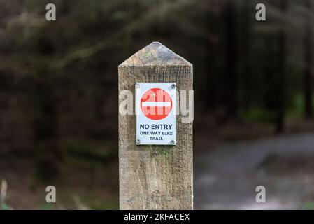 Foresta di Gisburn. Forrest of Bowland, Clitheroe, Lancashire Regno Unito. Nessun ingresso, un cartello informativo di sola andata per la pista ciclabile attaccato al palo della recinzione in legno. Foto Stock