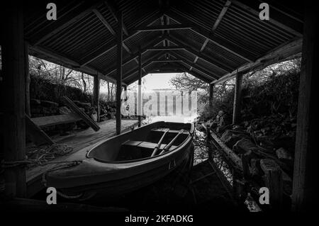 La casa barca sul Loch Achilly su una mattina nuvolosa autunno. Foto Stock