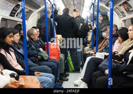 Affollato treno della metropolitana di Londra, passeggeri in piedi all'interno della carrozza della metropolitana, Piccadilly Line, trasporto pubblico TFL, Londra UK Foto Stock