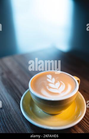 cappuccino o caffè latte fresco e saporito con schiuma lattea sul tavolo di legno nella caffetteria Foto Stock