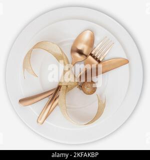 Vista dall'alto sul tavolo di Natale. Posate dorate e decorazioni isolate su piatti bianchi, elegante ristorante, cena di festa Foto Stock