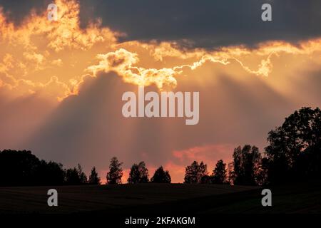 Il cielo nuvoloso sopra la collina silhouette catturato al tramonto Foto Stock
