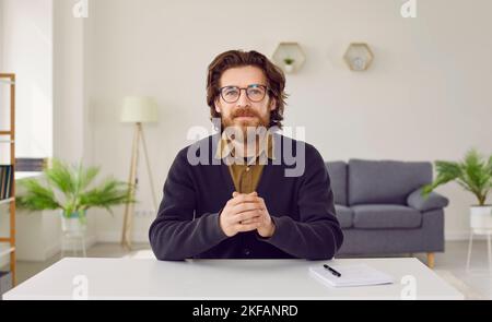 Ritratto di un uomo d'affari o di un insegnante seduto alla scrivania durante una videoconferenza Foto Stock