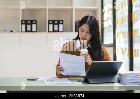 Giovane donna asiatica che lavora seriamente sul computer portatile in casa. Pensa a trovare la soluzione problema del lavoro Foto Stock