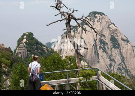 Donna occidentale turista caucasico visitatore e vista paesaggio visto dalla piattaforma di osservazione lungo il sentiero escursionistico sulle cime del monte Huashan / Monte Hua / Monte Hua vicino Huayin, Weinan, Cina. 714299. (125) Foto Stock