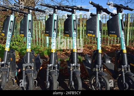 Vista frontale degli scooter elettrici Tier presso la stazione di parcheggio disponibile per il noleggio pubblico Foto Stock