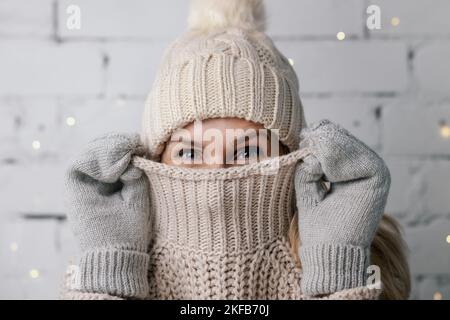 donna che nasconde il viso in lana maglione invernale. abbigliamento freddo Foto Stock