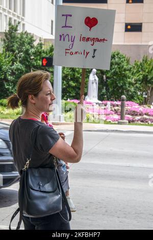 Luglio 2 2019 Tulsa USA -Donna che tiene il bambino e segno che dice che amo la mia famiglia immigrata si trova sull'angolo della strada per protestare con la statua della Vergine Maria Foto Stock