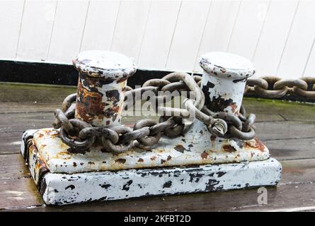 Scarpe da mare arrugginite con catene da ormeggio attaccate - grunge - scricchiolante vernice bianca - al porticciolo Foto Stock