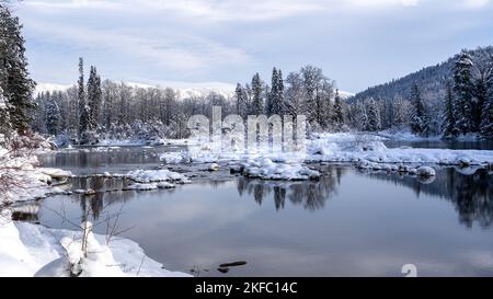 Innevate rocce e alberi al lago Still in inverno Foto Stock