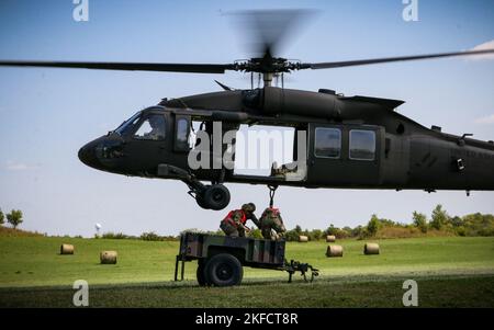 I soldati dell'esercito degli Stati Uniti agganciano un rimorchio ad un Hawk nero della guardia nazionale dell'esercito dell'Iowa UH-60 durante un'esercitazione di caricamento della cinghia come parte di un corso del Pathfinder degli Stati Uniti a Camp Dodge in Johnston, Iowa, il 8 settembre 2022. Quasi 30 soldati si sono laureati al corso, che è stato insegnato da una squadra di addestramento mobile presso il Centro di addestramento della Guardia Nazionale dell'Armata a Fort Benning, Georgia. I Pathfinder dell'esercito sono addestrati a fornire aiuti alla navigazione e servizi di consulenza agli aeromobili militari nelle aree designate dai comandanti di unità supportati. Durante il corso Pathfinder, gli studenti vengono istruiti sull'orientamento dell'aeromobile, aeromedi Foto Stock