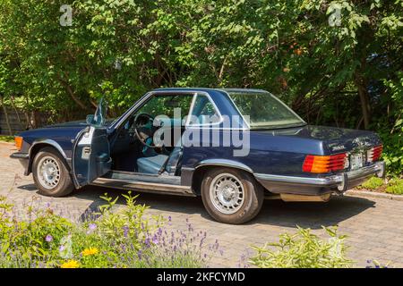 1972 blu Mercedes 350 SL con porta aperta sul lato conducente parcheggiata nel vialetto di accesso in pietra. Foto Stock